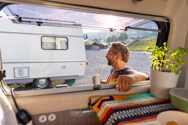 istock Man enjoying coffee outside camper van in the morning sun 2171200653