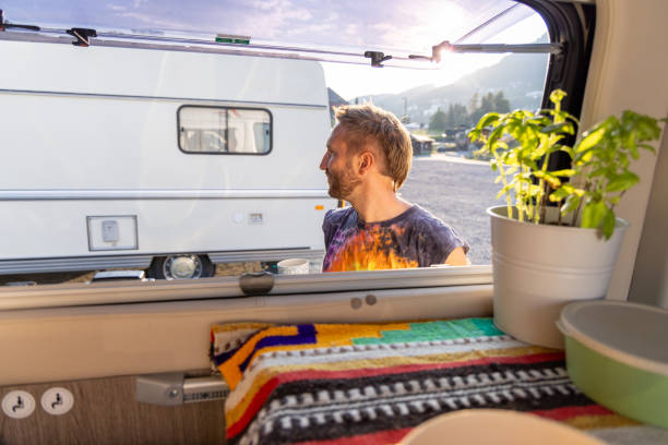 istock Man enjoying coffee outside camper van in the morning sun 2171200668