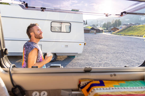 istock Man enjoying coffee outside camper van in the morning sun 2171200672