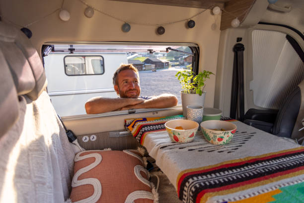 istock Man relaxing in cozy camper van with colorful decor 2171200683