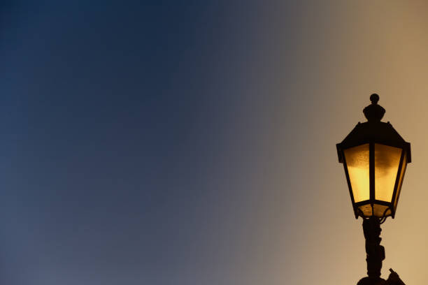 istock Old yellow glowing lantern against a dark sky, background for romantic poetry, glowing lantern in the evening sky 2171201146