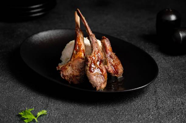 istock Grilled lamb chops with rice on a black plate. 2171201498