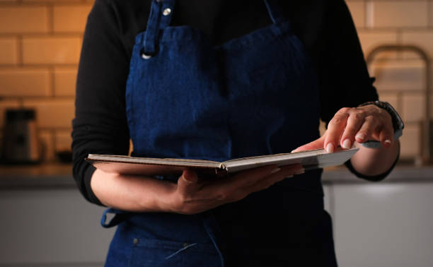 istock Woman Reading Reciepe Book In The Kitchen 2171204795