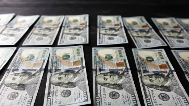 One Hundred USA Dollars Laid In Rows On A Table
