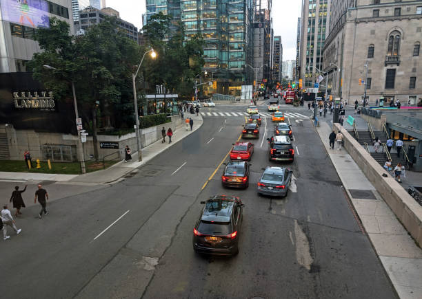 Toronto, Canada - August 22, 2024: Traffic heads north on York Street at Front Street West. Summer early evening in the Financial District.