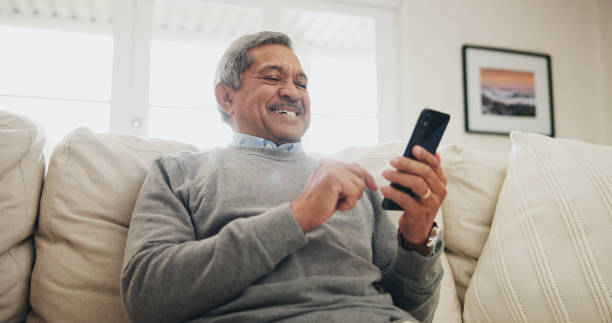 istock Home, senior man on sofa and smartphone with typing, internet and message for contact, texting and relax. Mature person, apartment and elderly guy on couch, cellphone and mobile user with network 2171209488