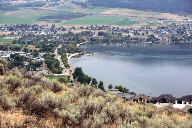 High angle of Vernon looking down to Lake Okanagan, Kin Beach,Resort, and Modern Homes.  Green hills in background.
