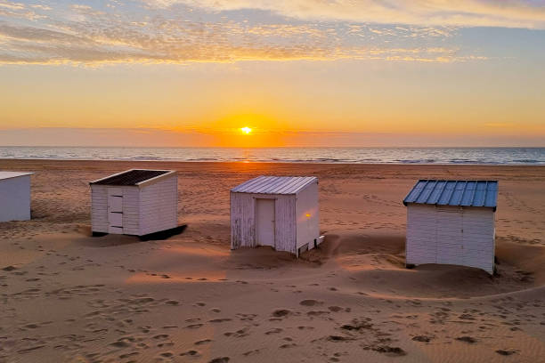 istock Tranquil Sunset Beach Scene with Three White Huts on Sandy Shoreline for Vacation Themes and Travel Design 2171221011