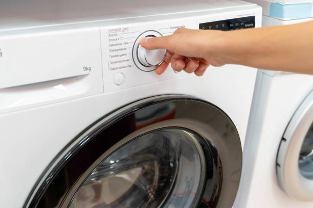 istock A hand reaches to select a wash cycle on the washing machine 2171226282