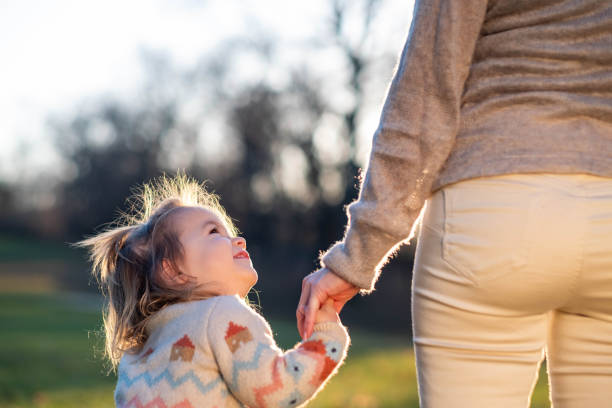 istock holding mom's hand in the park 2171229213