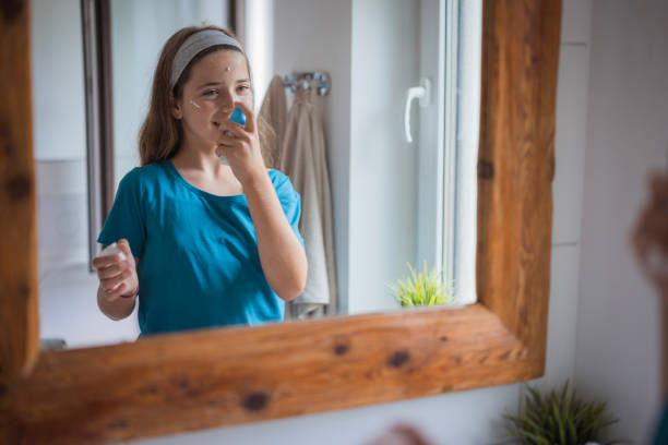 istock Happy girl applying face moisturizer 2171234789