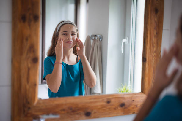istock Girl applying face cream and looking at the camera 2171234805