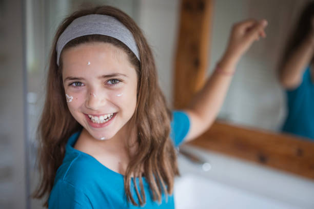 Close-up of a young girl having face cream applied in sports on her face