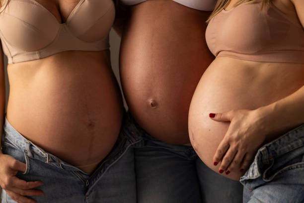 In the studio setting, three expectant mothers strike a pose