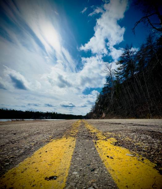 yellow road markings stretching into the distance against a blue sky