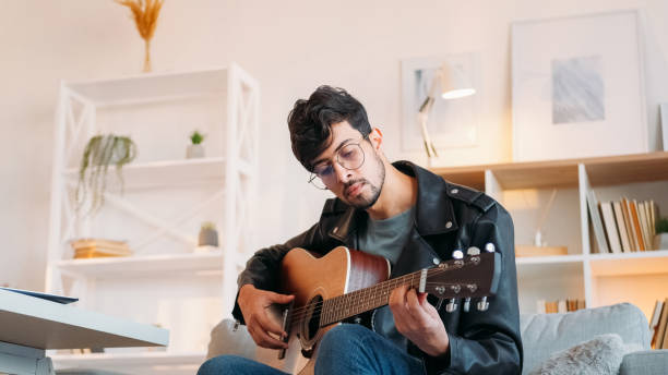 istock Guitar hobby music playing man tuning up strings 2171246861