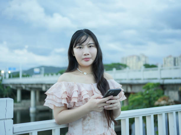istock Asian woman holding mobile phone 2171252255
