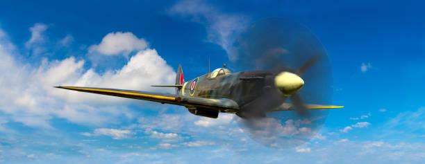 World War Two British Spitfire fighter plane flying in blue sky in a sunny day