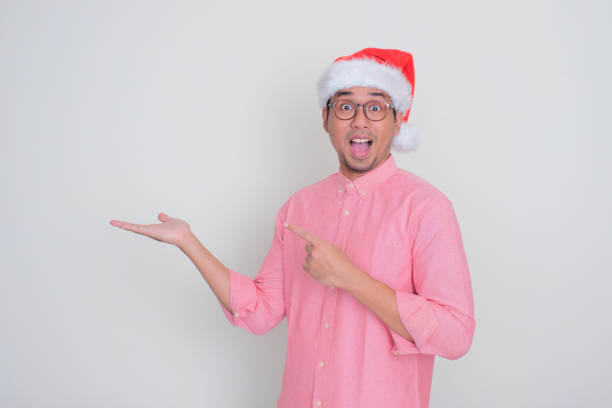 istock A man wearing christmas hat showing wow face while imaginary lift something on his hand 2171253083