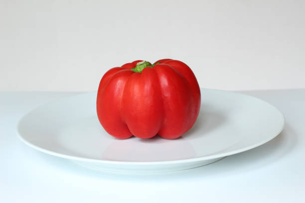 Woman is holding red bell pepper.