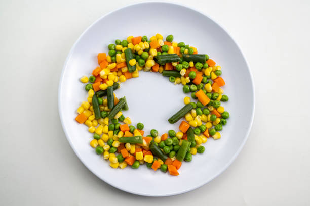 A plate of vegetables including corn, peas, and carrots