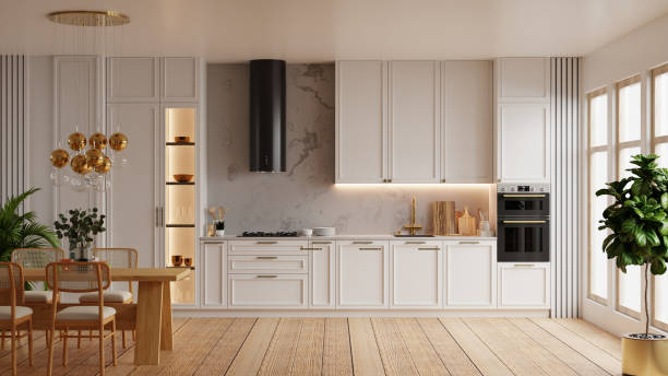 istock Kitchen features sleek white cabinets, a wooden dining table, and elegant gold accents, all beautifully illuminated by natural light streaming through large windows- 3D rendering 2171263338