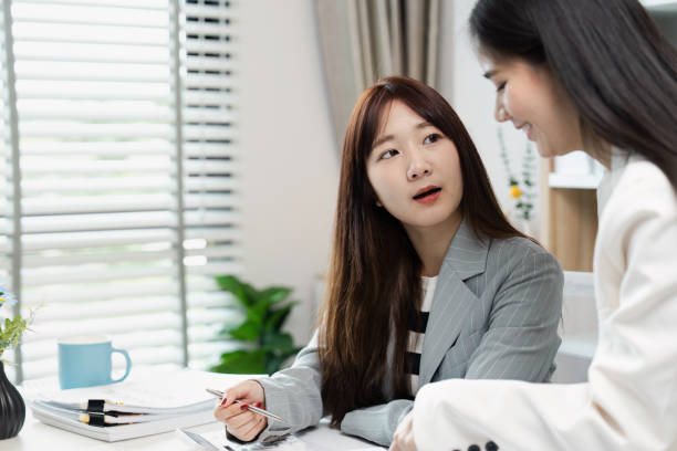 istock Professional Businesswomen Collaborating in Modern Office Environment with Documents and Technology 2171268178