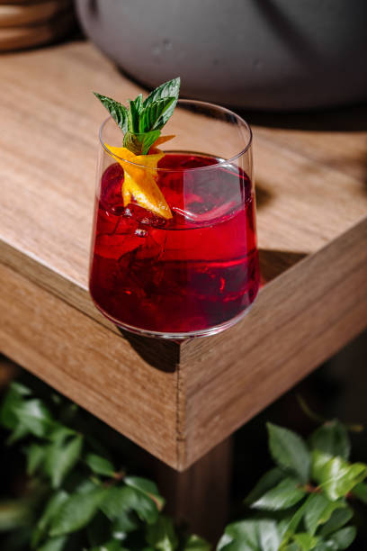 istock Red cocktail standing on wooden table with orange and mint garnish 2171272805