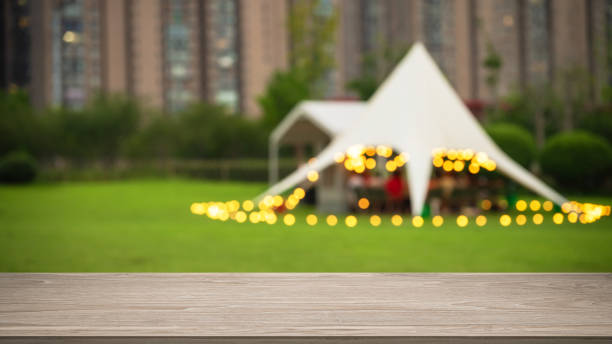 Empty wooden table top with dusk tent camping blurred abstract scenes