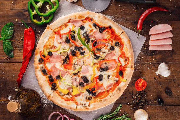 istock Delicious pizza lying on wooden table surrounded by fresh ingredients 2171274166