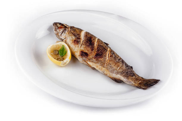 istock Grilled trout lying on white plate with lemon and capers 2171274171