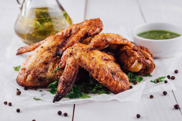 istock Delicious roasted chicken wings lying on white paper on white table 2171274198
