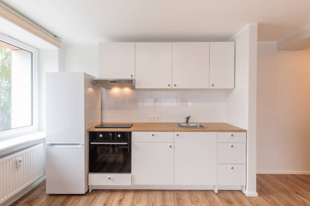 istock Scandinavian Style Cozy Modern Open Bright Minimalism Kitchen Home Interior. Oven, Faucet, Fridge and Furniture in Background. Dark Brown Flooring. White Cabinets 2171274658