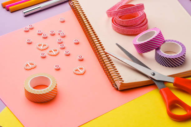 istock Scissors and decorative tape on colorful craft paper in a bright workspace 2171279119