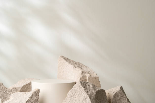 istock A minimalistic display featuring a smooth white cylinder surrounded by rough gray stone fragments 2171279366