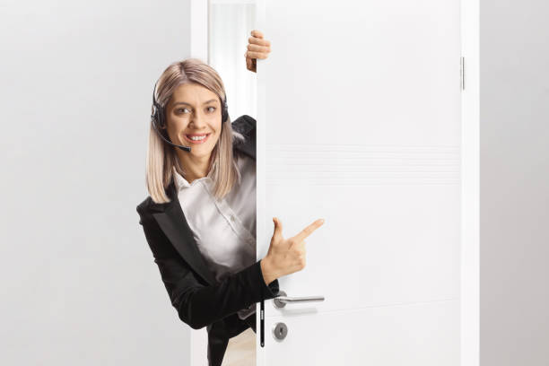 istock Female call operator with a headset standing behind a door 2171280693
