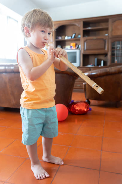 istock Little boy blowing the flute at home 2171281073