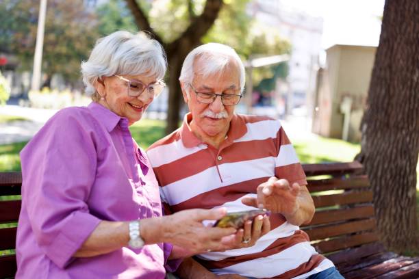 istock Senior couple surfing the net while sitting on the bench 2171285714