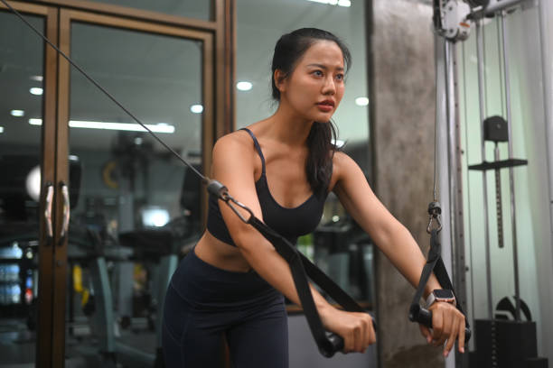 istock Determined athletic young woman working out in a gym, using a cable machine 2171288099