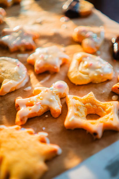 Baking Paper with Freshly Baked Biscuites with Sugar Coat and Springles in Different Forms for Christmas Close Up