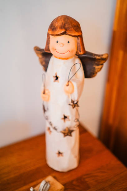 Smiling Angle Statue Holding a Star Standing on a Wooden Cupboard for Christmas