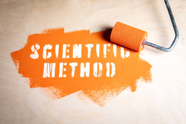 istock Scientific Method. Orange paint and paint roller on wood texture background 2171294598