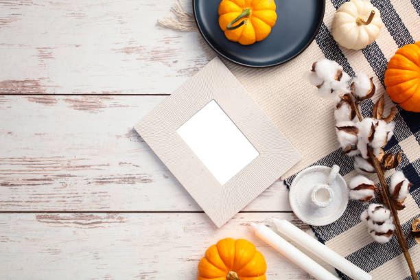 istock Autumn flat lay composition. Top view photo frame mockup, cotton branches, candles on checkered plaid on rustic wooden table. 2171294704