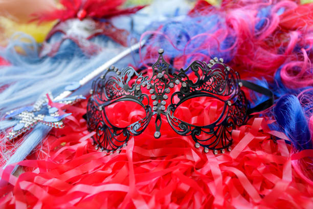 Close-up of black masquerade mask on multi colored background