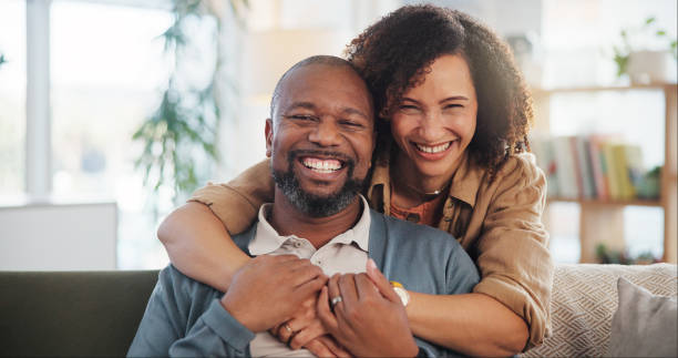 istock Couple, laughing and hug portrait in home for romance, support and commitment in marriage with love. Interracial people, security and embrace in living room of house for loyalty, comfort or affection 2171298094