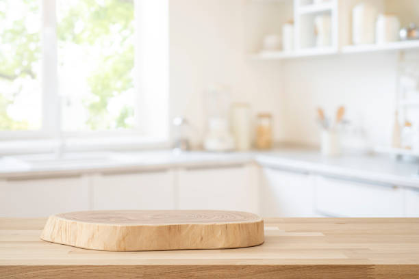 istock Table top with empty wooden podium for product montage on blur kitchen window interior background 2171303802