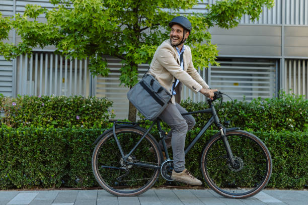 istock Smiling businessman commuting by bicycle in urban environment 2171307699