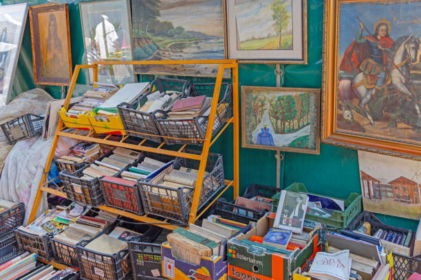 Belgrade, Serbia - August 10, 2024: Second Hand Books in Crates at Shelf and Old Paintings  Arts Antiques for Sale at Flea Market Stall Kalenic.