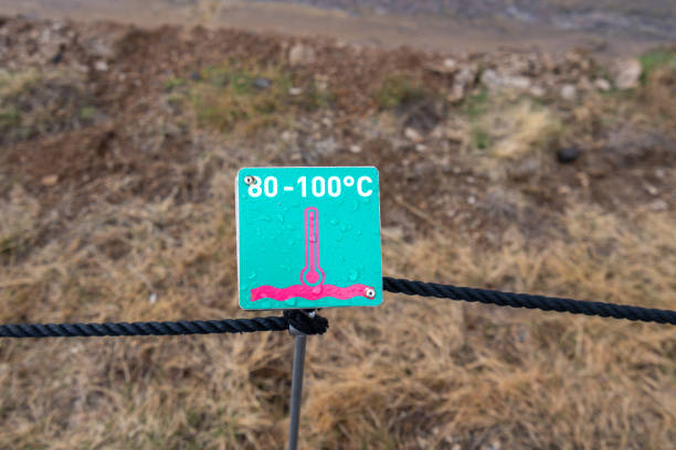 Geysir Geothermal Area, Iceland - May 6, 2024: A warning sign indicates boiling water in this active geothermal area. The sign, with a thermometer reading 80-100°C.