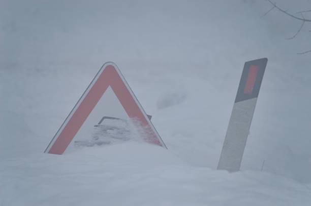 istock Snow-buried road danger signs during winter blizzard 2171311210